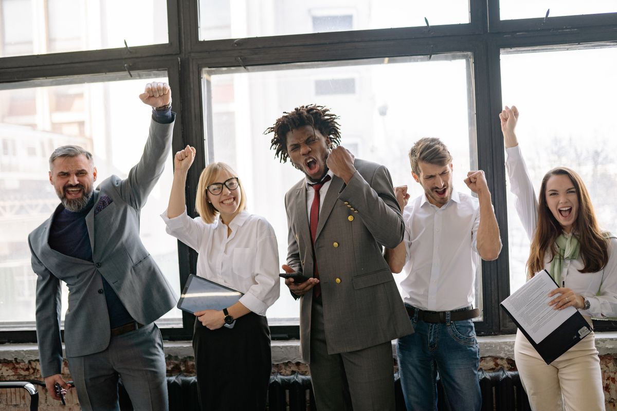 Ein Team im Büro jubelt gemeinsam über einen Erfolg.